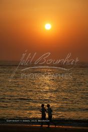 Image du Maroc Professionnelle de  Deux personnes pratique du footing au bord de la plage sous un magnifique coucher de soleil à Souiria Lekdima situé à 30 Km au sud de Safi, dans cette splendide région du Maroc sur l'océan atlantique. De nombreux européens profitent des joies de la mer sur cette plage un peu désertée par les marocains, le 14 Août 2003. (Photo / Abdeljalil Bounhar)